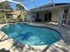 Beautiful in-ground pool with screen enclosure and a covered patio area for relaxing by the pool at 21498 Beaverton Ave, Port Charlotte, FL 33952