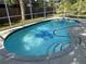 Private backyard swimming pool with screened enclosure, palm trees, and blue water at 21498 Beaverton Ave, Port Charlotte, FL 33952