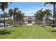 Stunning clubhouse with lush lawn, palm trees, and inviting architecture, creating a resort-like atmosphere at 262 Sapphire Lake Dr # 202, Bradenton, FL 34209