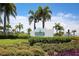 The Beach Club community sign surrounded by lush tropical landscaping under a sunny sky at 262 Sapphire Lake Dr # 202, Bradenton, FL 34209