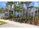 Charming gray exterior of home with palm trees, manicured landscaping, and sidewalk to front door at 262 Sapphire Lake Dr # 202, Bradenton, FL 34209