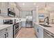 Modern kitchen features stainless steel appliances, gray cabinets, tile floors, and sleek countertops at 262 Sapphire Lake Dr # 202, Bradenton, FL 34209