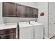 Bright laundry room with cabinets above washer and dryer, and a white countertop on the side at 262 Sapphire Lake Dr # 202, Bradenton, FL 34209