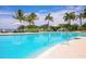 Gorgeous pool featuring clear blue water, palm trees, lounge chairs, and beautiful landscaping all around at 262 Sapphire Lake Dr # 202, Bradenton, FL 34209