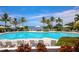 Inviting community pool surrounded by lush greenery, lounge chairs, umbrellas, and scenic waterfront views at 262 Sapphire Lake Dr # 202, Bradenton, FL 34209