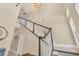 A staircase with carpeted stairs and white wood banisters ascends to the second story under a modern chandelier at 262 Sapphire Lake Dr # 202, Bradenton, FL 34209