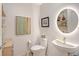 Stylish powder room with modern round mirror and floating shelves at 301 Quay Commons # 1208, Sarasota, FL 34236