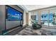 Lobby view including media wall, fireplace, luxury chair, and view of the pool area at 301 Quay Commons # 1208, Sarasota, FL 34236