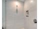 Modern glass shower features tiled walls and built in storage at 301 Quay Commons # 1208, Sarasota, FL 34236