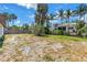 View of a weeded backyard with a water view at 310 Avenida Milano, Sarasota, FL 34242
