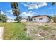 View of a backyard featuring a large grassy space and mature trees; great potential for outdoor activities at 310 Avenida Milano, Sarasota, FL 34242