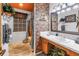 Stylish bathroom with brick accent wall, tile flooring and neutral-toned decor at 3311 Florida Blvd, Bradenton, FL 34207