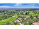 An aerial shot displays a golf course community with verdant fairways, winding paths, picturesque ponds, and inviting residences at 3388 Highlands Bridge Rd, Sarasota, FL 34235