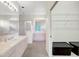 Bright bathroom featuring double vanities, a glass shower and an open walk-in closet at 3388 Highlands Bridge Rd, Sarasota, FL 34235