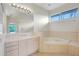 Bathroom featuring a tub, large mirror, and neutral tiled counter tops at 3388 Highlands Bridge Rd, Sarasota, FL 34235