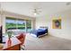 Bright bedroom with pool view, desk, ceiling fan, and unique artwork at 3388 Highlands Bridge Rd, Sarasota, FL 34235