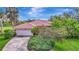Beautiful single-story home featuring a red tile roof, attached garage and lush landscaping at 3388 Highlands Bridge Rd, Sarasota, FL 34235