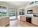 Bright kitchen area features terracotta tile flooring, neutral cabinets, and a pool view at 3388 Highlands Bridge Rd, Sarasota, FL 34235