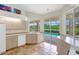 The kitchen features warm terracotta tile, neutral cabinetry, a view of the pool, and natural light at 3388 Highlands Bridge Rd, Sarasota, FL 34235