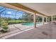 A stunning covered and screened-in patio with a view of the pool and landscaped golf course at 3388 Highlands Bridge Rd, Sarasota, FL 34235