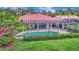 Backyard view of a screened in pool area, surrounded by lush greenery and hedges for enhanced privacy at 3388 Highlands Bridge Rd, Sarasota, FL 34235