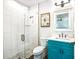 Bright bathroom with a turquoise vanity and glass shower, featuring clean white tiles and modern fixtures at 340 Jackson Dr, Sarasota, FL 34236