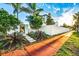 Well-maintained landscaped front yard with privacy wall, mature trees, and walkway at 340 Jackson Dr, Sarasota, FL 34236