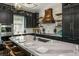 Stunning kitchen featuring dark cabinets, marble backsplash, a custom hood, and island with seating at 340 Jackson Dr, Sarasota, FL 34236