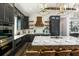 Kitchen featuring dark cabinetry, stainless appliances, an island with bar seating, and tile backsplash at 340 Jackson Dr, Sarasota, FL 34236