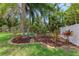Serene backyard garden with colorful landscaping, mulch beds, and a charming garden bench at 3707 Kingswood Dr, Sarasota, FL 34232