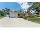 A single-story home features an attached garage, a spacious driveway, and manicured landscaping at 3707 Kingswood Dr, Sarasota, FL 34232