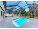 Sparkling in-ground pool surrounded by a screened enclosure, patio area, and lush greenery at 3707 Kingswood Dr, Sarasota, FL 34232