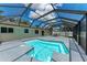 Relaxing in-ground pool and spacious deck area within a screened-in enclosure for outdoor enjoyment at 3707 Kingswood Dr, Sarasota, FL 34232