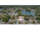 An aerial view of a home with a metal roof, a manicured lawn, and a pond in the background at 3921 Marlborough Pl, Sarasota, FL 34241