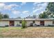 View of home's back exterior with patio, metal roof, and lush lawn at 3921 Marlborough Pl, Sarasota, FL 34241