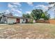 Back exterior featuring a well-maintained lawn and partial lake view beyond the fence at 3921 Marlborough Pl, Sarasota, FL 34241