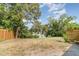 Spacious backyard with grass, trees, and a partial view of a serene lake at 3921 Marlborough Pl, Sarasota, FL 34241