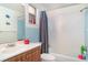 Clean bathroom with blue tile, vanity sink, toilet, and tub shower combo at 3921 Marlborough Pl, Sarasota, FL 34241