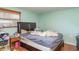 Bedroom with wood floors, large bed, side table, and window with blinds at 3921 Marlborough Pl, Sarasota, FL 34241