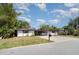 Well-maintained single-story home with a large driveway, lush lawn and mature trees at 3921 Marlborough Pl, Sarasota, FL 34241