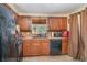 Functional kitchen with wooden cabinets, black appliances, and tile backsplash at 3921 Marlborough Pl, Sarasota, FL 34241