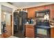 View of the kitchen with wood cabinets, black appliances, and tile flooring at 3921 Marlborough Pl, Sarasota, FL 34241