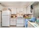 Kitchen with white appliances and cabinetry and double basin sink at 3921 Marlborough Pl, Sarasota, FL 34241