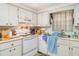 Kitchen with white appliances, double basin sink, and cabinets at 3921 Marlborough Pl, Sarasota, FL 34241