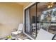 A relaxing view looking from a furnished balcony into the home. A desk can be seen inside at 4061 Crockers Lake Blvd # 27, Sarasota, FL 34238