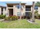 Beautiful condo exterior featuring lush landscaping with green grass, plants, and palm trees at 4061 Crockers Lake Blvd # 27, Sarasota, FL 34238
