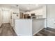 Open kitchen featuring white cabinets, granite counters, and stainless appliances, seamlessly connected to entryway at 4061 Crockers Lake Blvd # 27, Sarasota, FL 34238