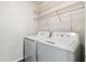 Clean laundry area with a white washer and dryer and practical shelving for organized storage at 4061 Crockers Lake Blvd # 27, Sarasota, FL 34238