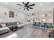 Open-concept living room with gray sofa, kitchen bar seating, and wood-look flooring at 4307 Manfield Dr, Venice, FL 34293