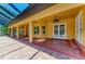 Covered back patio with brick flooring, ceiling fans, and access to the pool area at 4647 Stone Ridge Trl, Sarasota, FL 34232